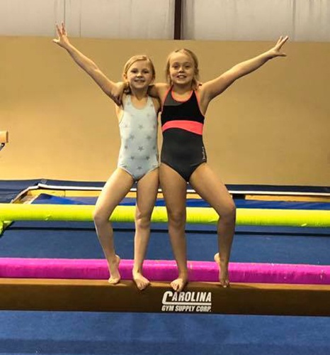 Two Girls posing on balance beam