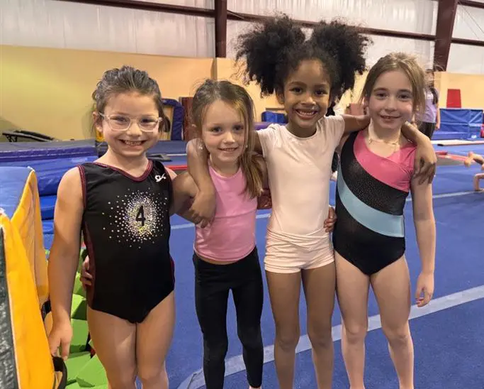 Four girls in gymnastics smiling at Siouxland Academy